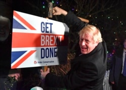 Britain's Prime Minister and Conservative party leader Boris Johnson poses as he hammers a "Get Brexit Done" sign into the garden of a supporter, in Benfleet, east of London on Wednesday, Dec. 11, 2019.