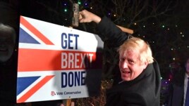 Britain's Prime Minister and Conservative party leader Boris Johnson poses as he hammers a 