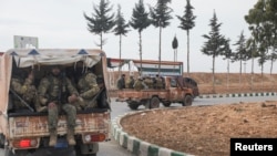 Combatientes rebeldes sentados en un vehículo en el campo de Homs, después de que los rebeldes sirios impulsaran su avance relámpago el sábado, diciendo que habían capturado la mayor parte del sur en Siria, 7 de diciembre de 2024. REUTERS