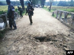 FILE - Myanmar soldiers view the crater from a landmine explosion on a bridge in Maung Nama Taung village of Maungdaw, in Rakhine State near the Bangladesh border, Nov. 12, 2016, in this handout photograph released by the Myanmar Armed Forces.