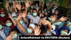 Siswa penyandang disabilitas yang memakai masker pelindung bereaksi di sekolah di tengah COVID-19, di Lhokseumawe, Aceh, 6 Maret 2020. (Foto: Antara/Rahmad via REUTERS)