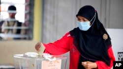 A woman casts her ballot during the election at a polling station in Seberang Perai, Penang state, Malaysia, Nov. 19, 2022. 