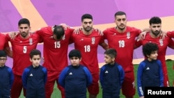 Iran players listen to the national anthem ahead of the Qatar 2022 World Cup Group B football match between England and Iran at the Khalifa International Stadium in Doha, Nov. 21, 2022. 