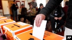 FILE - A vote is cast in Auckland, New Zealand, during a general election on Sept. 3, 2014.