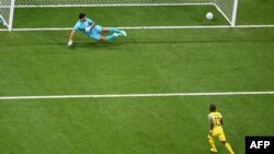 Ecuador's forward Enner Valencia (L) scores his team's first goal from the penalty spot as Qatar's goalkeeper Saad Al Sheeb eyes the ball during the Qatar 2022 World Cup Group A opener at the Al-Bayt Stadium in Al Khor, north of Doha on November 20, 2022.