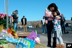 Crystal and Ella Mondragon place flowers at a makeshift memorial near a gay nightclub, site of a shooting late Saturday night, in Colorado Springs, Colorado, Nov. 20, 2022.