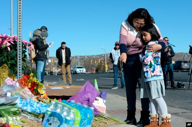 Crystal and Ella Mondragon place flowers at a makeshift memorial near a gay nightclub, site of a shooting late Saturday night, in Colorado Springs, Colorado, Nov. 20, 2022.