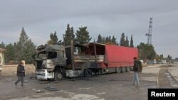 Locals inspect a burned truck hit by one of the rockets fired from northern Syria in the Karkamis district, near a border gate in Gaziantep province, Turkey November 21 2022 in this still image from video. (Ihlas News Agency via Reuters)