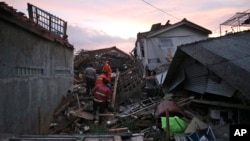 Rescuers search for survivors amid ruins of houses damaged by an earthquake in Cianjur, West Java, Indonesia, Nov. 21, 2022. 