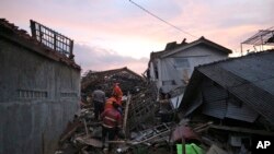 Rescuers search for survivors amid ruins of houses damaged by an earthquake in Cianjur, West Java, Indonesia, Nov. 21, 2022. 