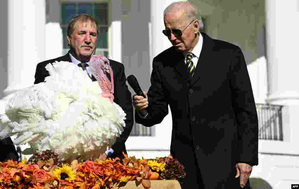 President Joe Biden pardons Chocolate, the National Thanksgiving Turkey, as he is joined by the National Turkey Federation Chairman Ronnie Parker (left) on the South Lawn of the White House in Washington.