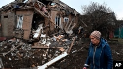 A woman walks past her house, severely damaged by Russian shelling, in Kramatorsk, Ukraine, Nov. 19, 2022.