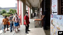 Voters wait in a line to cast their ballots for general election at a polling station in Kuala Lumpur, Malaysia, Nov. 19, 2022. 