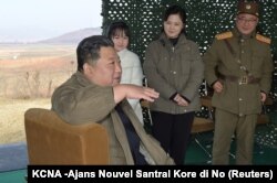 Pemimpin Korea Utara Kim Jong Un, bersama istrinya Ri Sol Ju dan putri mereka, berbicara pada hari peluncuran rudal balistik antarbenua (ICBM), 19 November 2022. (Foto: KCNA via reuters)