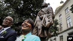 Bernice King (kanan) putri Dr. Martin Luther King Jr., berdiri di dekat patung ayahnya di Atlanta, Senin (28/8). 