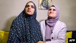 Marah Bakr (L) a Palestinian detained in Israeli prison for eight years and released on November 24, 2023, under a truce deal between Israel and Hamas in exchange for hostages held in Gaza, looks on as her mother Sawsan sits by her side in their home in e