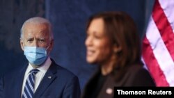 A la izquierda, Joe Biden, que se proyecta como presidente electo de EE.UU., observa a su compañera de fórmula, la senadora Kamala Harris, durante su intervención desde WIlmington, Delaware, el 10 de noviembre de 2020.