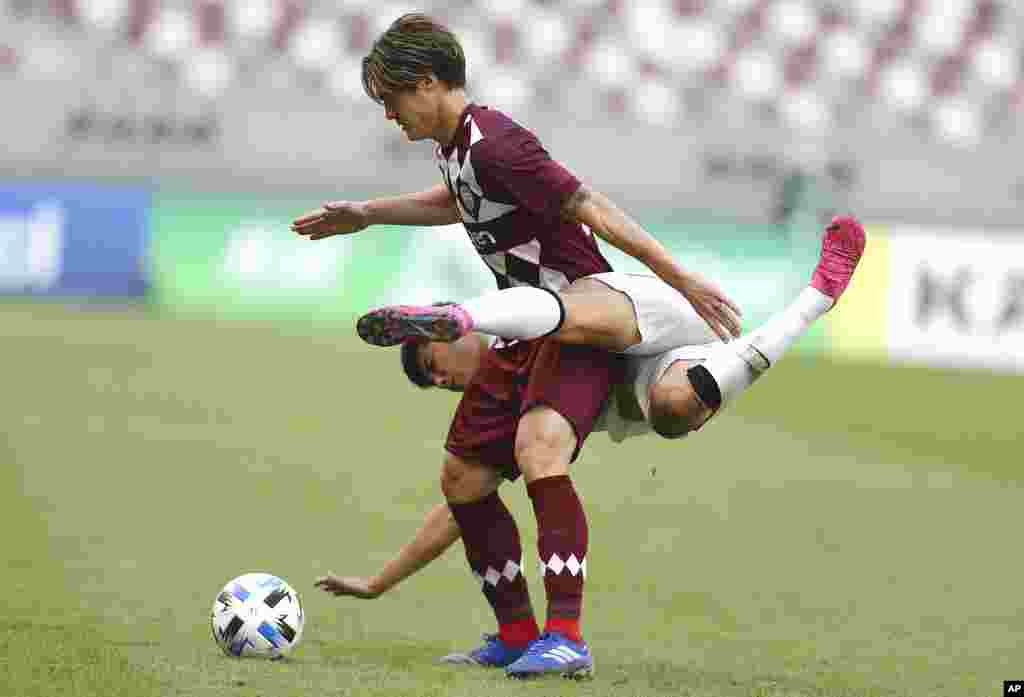 Shanghai SIPG&#39;s Li Shenglong and Vissel Kobe&#39;s Gotoku Sakai, top, fight for the ball during a round of 16 AFC Champions League match in Doha, Qatar.