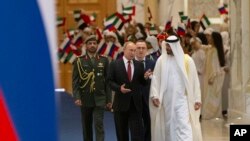 Russian President Vladimir Putin, foreground left, and Abu Dhabi Crown Prince Mohamed bin Zayed al-Nahyan, right, are seen at the official welcoming ceremony for Putin, in Abu Dhabi, United Arab Emirates, Oct. 15, 2019.