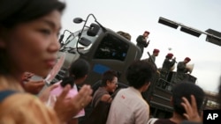 Thai soldiers entertain passers-by while providing security at Bangkok's Victory Monument in Thailand Thursday, June 5, 2014.