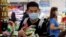 A man wearing a protective mask looks for the start of the queue at a grocery store in Taguig, metropolitan Manila, Philippines, March 13, 2020.