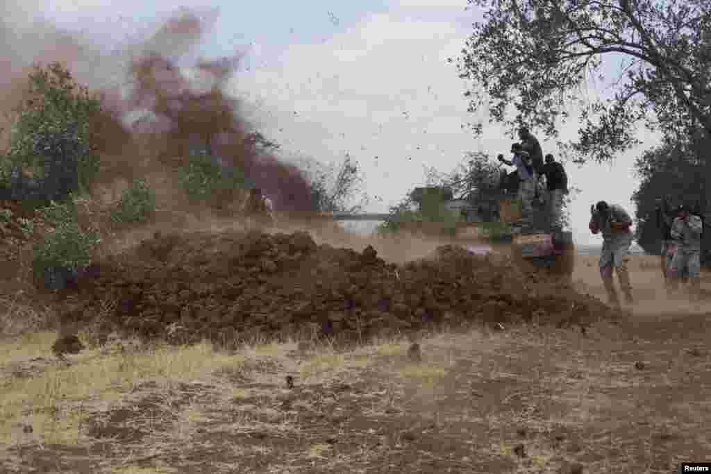 Free Syrian Army fighters fire from a tank during what they say is an offensive against the forces of Syria&#39;s President Bashar al-Assad in the southern city of Deraa, Syria.