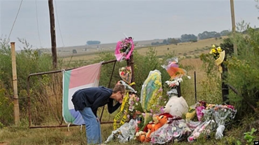 A supporter of African far-right leader Euguene Terre'Blanche looks at flowers and pays tribute in front of the entrance of the farm in Ventersdorp, 05 Apr 2010