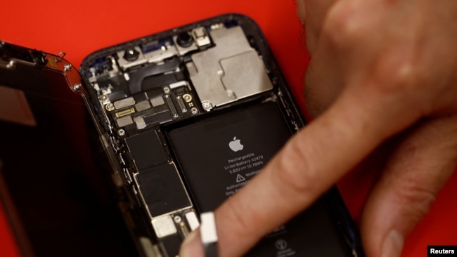 An employee checks an Apple iPhone 12 in a mobile phone store in Nantes, France on September 13, 2023. (REUTERS/Stephane Mahe)