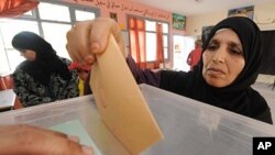 A Moroccan posts her ballot at a voting station in Sale, near Rabat, July 1, 2011