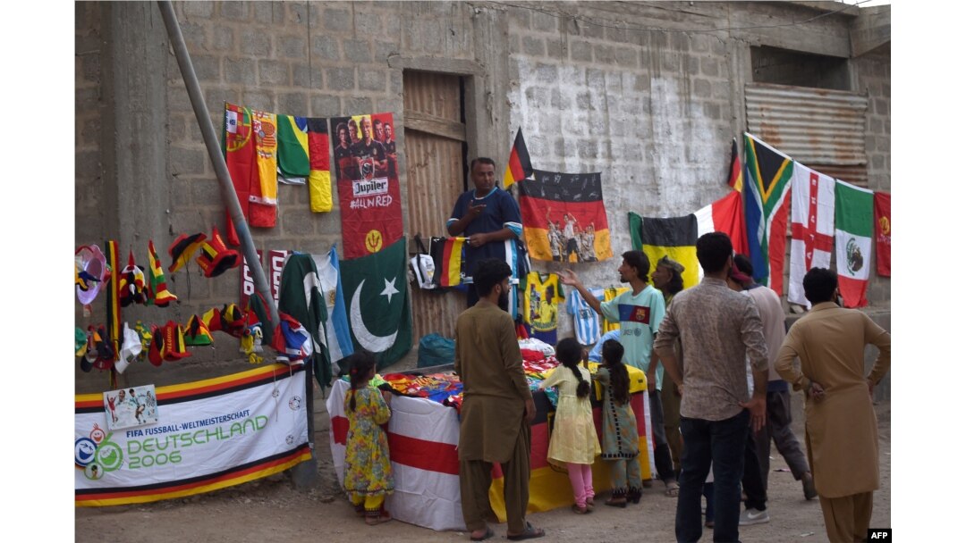FILE - Football fans gather around a stall selling national flags and football related items ahead of Qatar 2022 FIFA World Cup football tournament, in Karachi on Nov. 12, 2022.