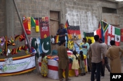 FILE - Football fans gather around a stall selling national flags and football related items ahead of Qatar 2022 FIFA World Cup football tournament, in Karachi on Nov. 12, 2022.