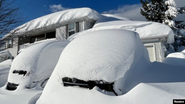 Vehicles and a home are covered in a snowdrift during a lull in a snow storm hitting the northern New York state area, in Hamburg, New York, Nov. 19, 2022. (Sarah Irwin/Handout via Reuters)