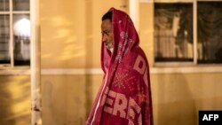 A migrant man from Nicaragua is wraps himself in a blanket at a church in Piedras Negras, Mexico, on Nov. 16, 2022.