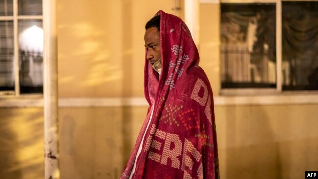 A migrant man from Nicaragua is wraps himself in a blanket at a church in Piedras Negras, Mexico, on Nov. 16, 2022.