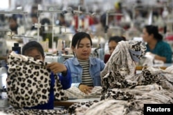 FILE - Employees work at a garment factory in Kandal province, Cambodia, Dec. 12, 2018.