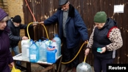 People fill up bottles with water near Dnipro river after Russia's military retreat from Kherson, Ukraine, Nov. 21, 2022. 