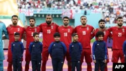 Los jugadores de Irán escuchan el himno nacional antes del partido de fútbol del Grupo B de la Copa del Mundo de Qatar 2022 entre Inglaterra e Irán, en el Estadio Internacional Khalifa en Doha, el 21 de noviembre de 2022.