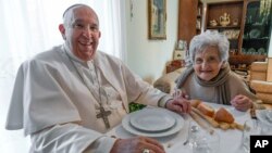 In this image made available by Vatican Media, Pope Francis sits for lunch in the home of a cousin, Carla Rabezzana, in the town of Portacomaro, about 10 kilometers east of Asti, northern Italy, Nov. 19, 2022.