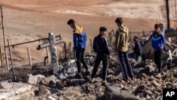 People inspect a site damaged by Turkish airstrikes that hit an electricity station in the village of Taql Baql, in Hasakeh province, Syria, Nov. 20, 2022. 