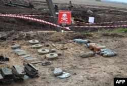 FILE - Unexploded munitions and other explosive devices are seen as members of a demining team of the State Emergency Service of Ukraine clear mines off a field not far from the town of Brovary, northeast of Kyiv, April 21, 2022.