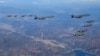 Dua jet pembom AU AS (atas C), jet tempur AU Korsel (kanan) terbang di atas Semenanjung Korea Selatan selama latihan udara bersama. Kedua negara terlibat dalam pembicaraan yang dapat memberi Seoul peran lebih besar dalam pengoperasian kekuatan nuklir AS, (Foto: AFP)