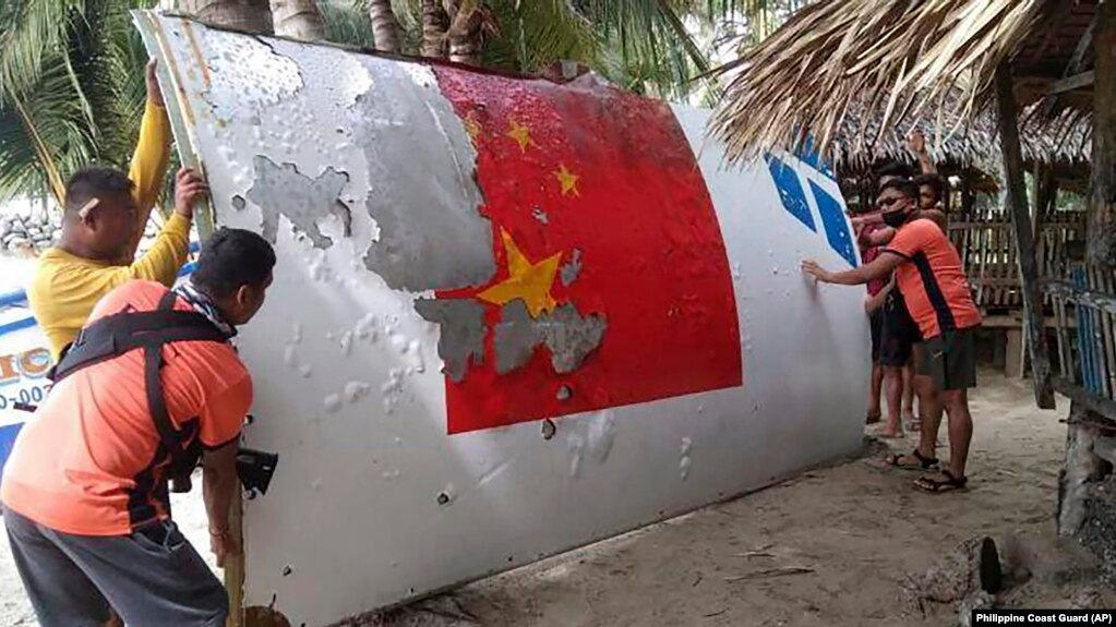 资料照：菲律宾海岸警卫队发布的照片显示，菲律宾海岸警卫队队员在曼布劳海岸外捞起的一块有着中国长征-5B号标识的残片。（2022年8月）(photo:VOA)