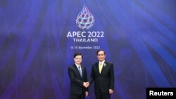 香港特首李家超（左）2022年11月18日在出席亚太经合组织峰会期间与东道主泰国总理握手。（亚太经合组织2022年峰会照片）