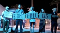 Activists hold signs at the COP27 U.N. Climate Summit, Nov. 19, 2022, in Sharm el-Sheikh, Egypt.