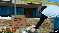 Elijah Newcomb of Colorado Springs lays flowers near a gay nightclub in Colorado Springs, Colo., Nov. 20, 2022 where a shooting occurred late Saturday night. 