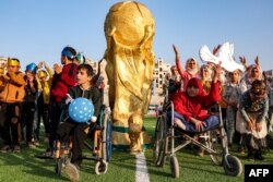 Djeca poziraju uz maketu pehara Svjetskog prvenstva tokom ceremonije otvaranja "Camps World Cupa" na novootvorenom gradskom stadionu u Idlibu, 19. novembar 2022.