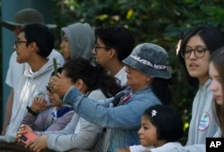 Visitors take photos of Xin Xin, a 32-year-old Mexican-born giant panda, at the Chapultepec Zoo in Mexico City, Friday, Nov. 11, 2022. (AP Photo/Fernando Llano)