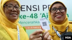 Peserta Muktamar yang memiliki hak pilih menunjukkan barcode e-voting, Jumat (18/11). (Foto: VOA/ Yudha Satriawan)