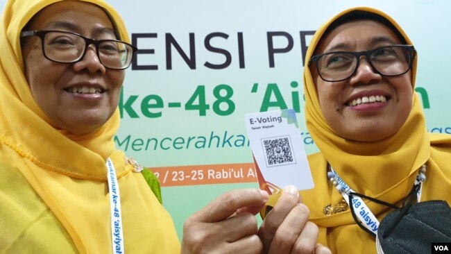 Peserta Muktamar yang memiliki hak pilih menunjukkan barcode e-voting, Jumat (18/11). (Foto: VOA/ Yudha Satriawan)