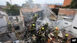 Bomberos trabajan en el lugar del accidente de una avioneta que cayó sobre casas en una zona residencial de Medellín, Colombia, el 21 de noviembre de 2022.